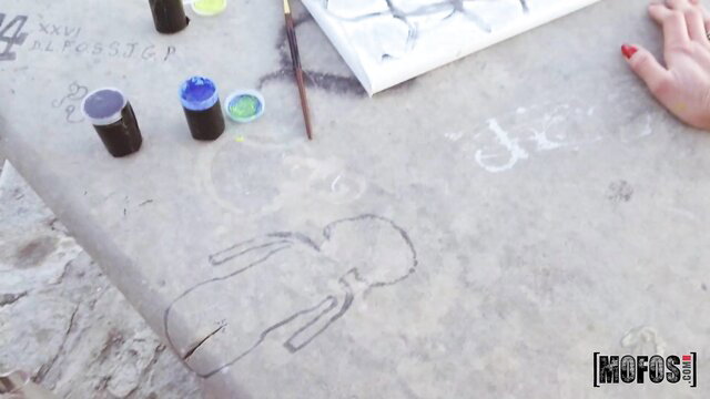 Sasha Coxx painting at table in public pickup tease