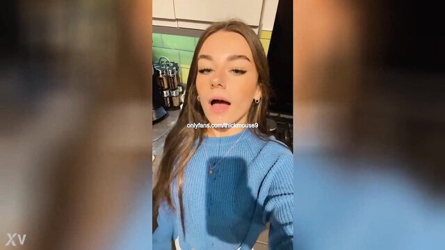 Cute brunette in tight blue sweater takes selfie video, teasing lips