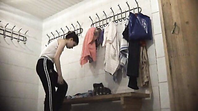 Young brunette teen undressing in locker room voyeur style