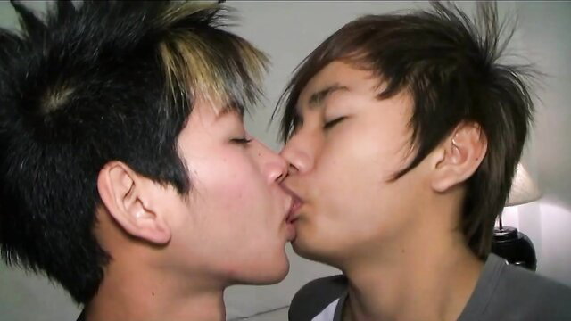 Cute Asian college boys kissing passionately in hotel room