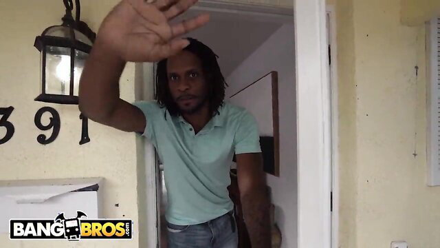 Dreadlocked black stud in green polo waves hand at door in BangBros Halloween 2022