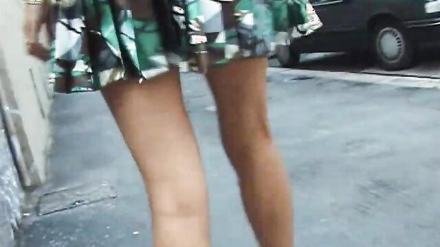 Slim Asian babe in short colorful skirt flashes upskirt on street