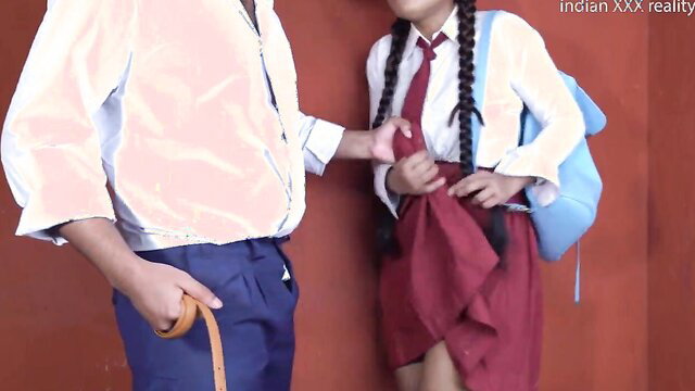 Indian college girl in school uniform with teacher holding her skirt