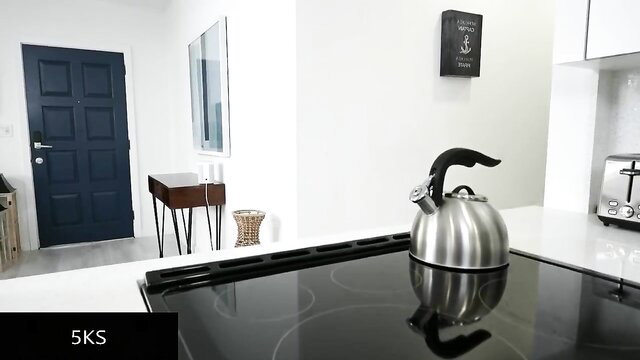 Kat Marie in sleek modern kitchen with kettle on stove