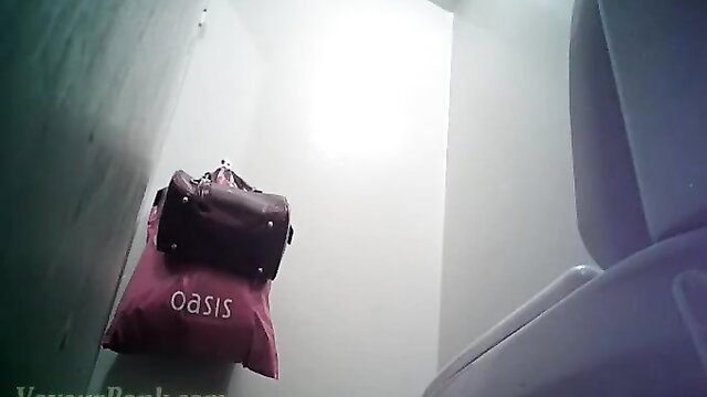 Skinny blonde with Oasis bag in airplane lavatory voyeur view