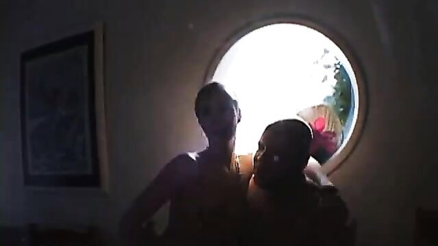 Two busty black babes in lingerie kissing passionately by porthole