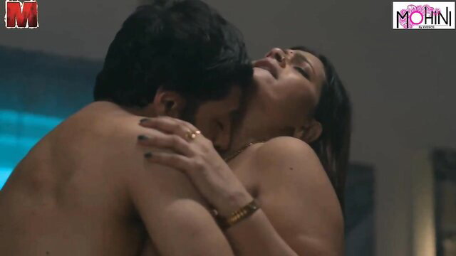Latina woman kissing a man with visible gold jewelry