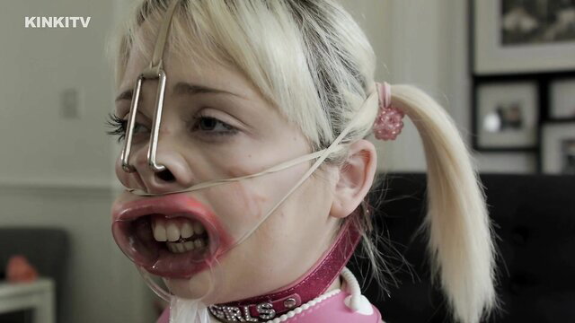 Blonde petgirl Cherry Pig in pig nose gag, mouth spreader, pink collar