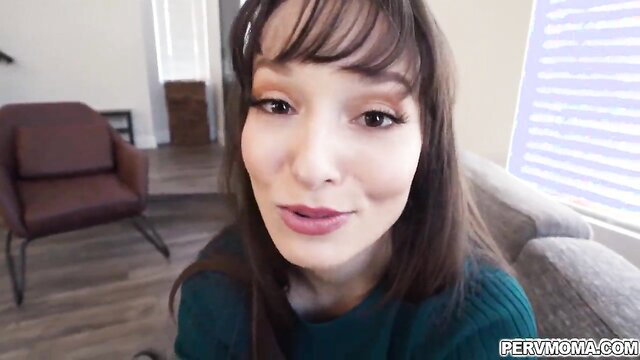 Lexi Luna smiling seductively in green top, bangs and long brown hair