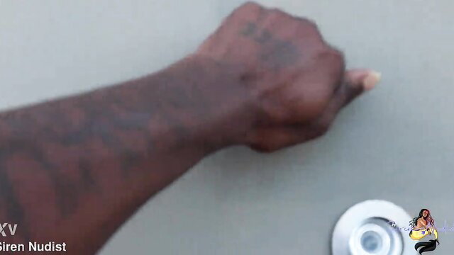 Tattooed black man's muscular arm pointing at drain in Popeyes employee trailer
