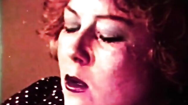 Vintage redhead bombshell with plump lips in sultry close-up gaze