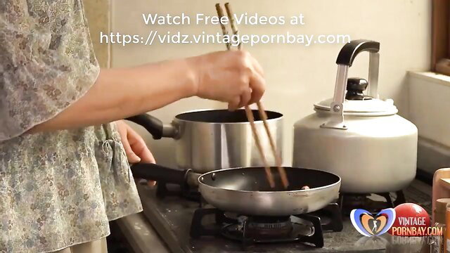 Chinese MILF cooking in kitchen with chopsticks, sexy dress