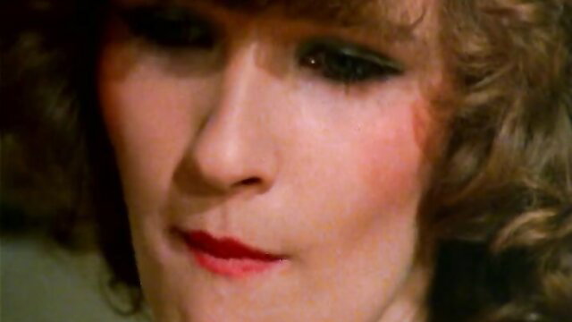 Closeup of sultry brunette with red lips in vintage adult film