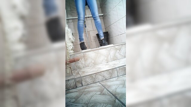 Skinny babe in tight blue jeans and boots filmed in toilet room