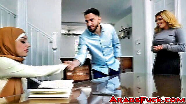 Devout Arab Muslim woman in hijab with pierced nipples at table with man and blonde