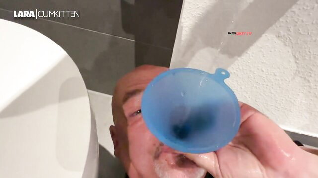 Lara CumKitten holds cum-filled blue funnel over toilet in tease