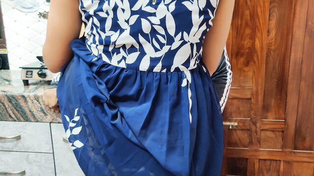 Japanese wife in blue floral dress bending over in kitchen