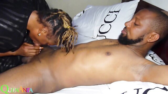 Black woman with dreads kisses muscular black man's huge cock on bed