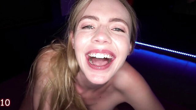 Rebel Rhyder topless smiling wide, blonde beauty in neon-lit closeup