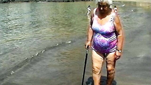 Elderly curvy granny in swimsuit at beach with cane, hairy pussy tease MILF