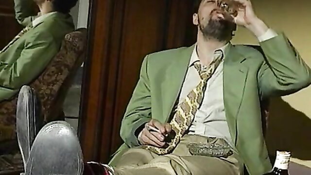 Man in green suit sips drink in steamy threesome setup