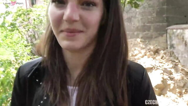 Shy Czech brunette in leather jacket smiles outdoors on street POV