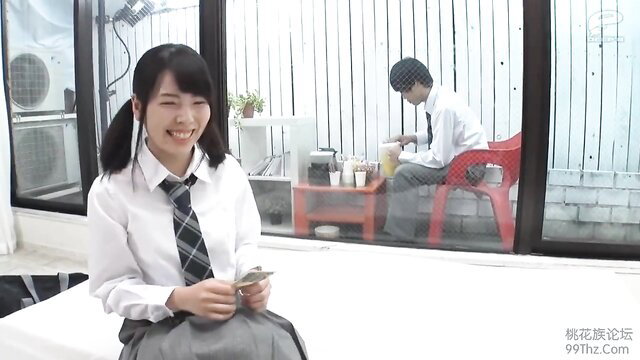 Cute Japanese schoolgirl in uniform smiles with phone, guy watches