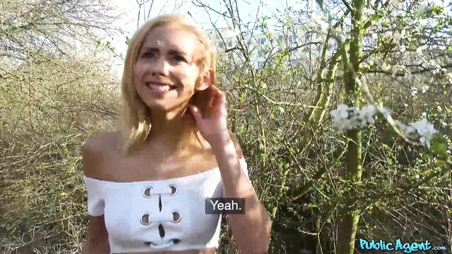 Blonde with big tits smiles in sexy off-shoulder top outdoors