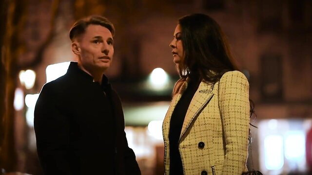 Couple standing together at night, man and woman talking