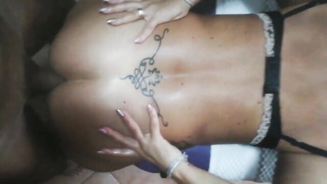 Tattooed woman in black lingerie with hands on big ass after massage