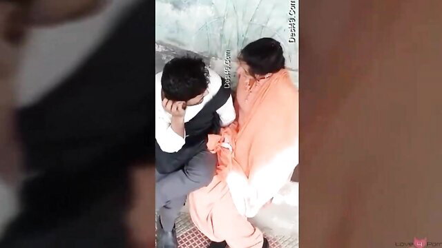 Indian couple in passionate outdoor embrace, man kissing mature woman