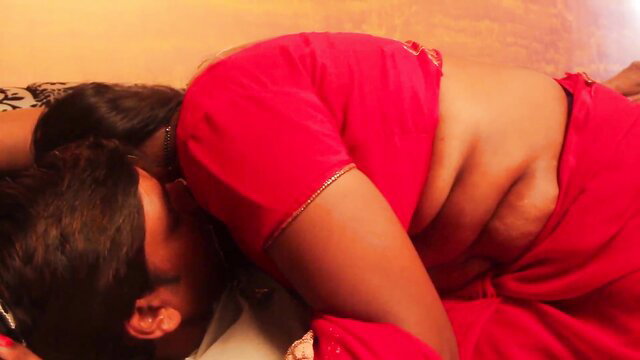 Curvy Indian woman in red saree blouse, exposed midriff, lying seductively