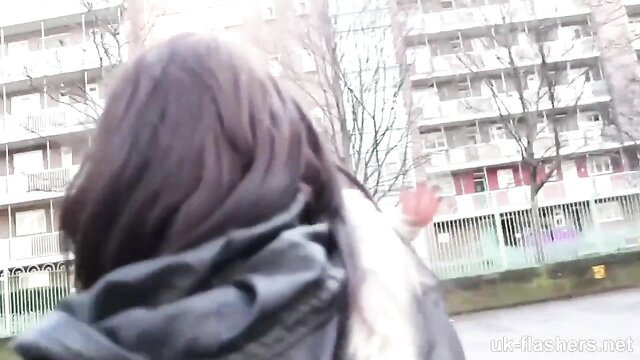 Woman waving outdoors in front of UK apartments