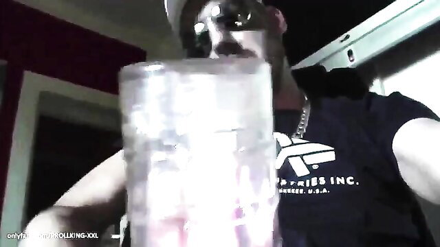 Muscular guy in shades holds clear glass of liquid close-up POV tease