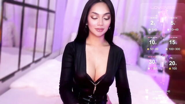 Asian cam girl in deep cleavage black latex dress teases on Chaturbate