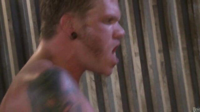 Muscular tattooed biker yells passionately in garage sex scene with Stormy Daniels