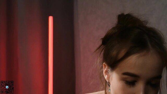 Hot teen closeup with sultry eyes and messy brown hair in neon glow