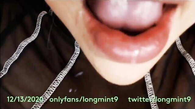 Closeup of woman's open mouth and tongue with glossy red lips