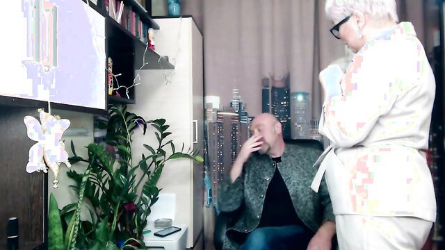 Mature MILF secretary in white dress chats with bald man