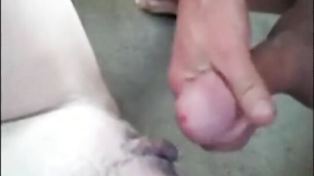 Closeup of black hand squeezing swollen white cock and balls