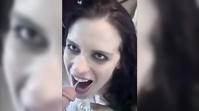 Hot goth girl with pale skin and dark hair sucking lollipop closeup
