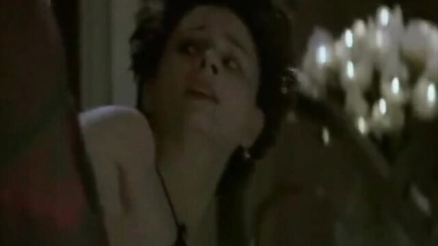 Closeup of shocked brunette woman with glossy lips in dim-lit erotic scene