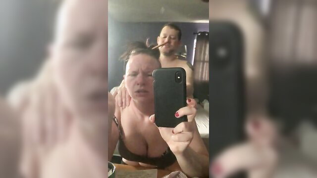 Stacey 29 by Samuel Malabar: busty white woman in bra, man behind smoking