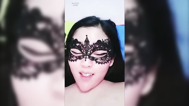 Asian beauty in black lace masquerade mask teases topless closeup