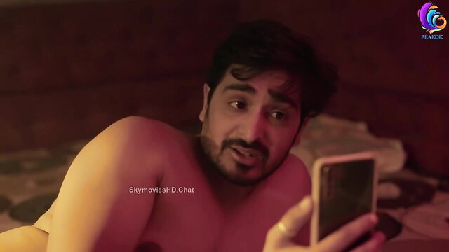 Nude Indian man lying on bed holding phone, Makhan App Sandook web series