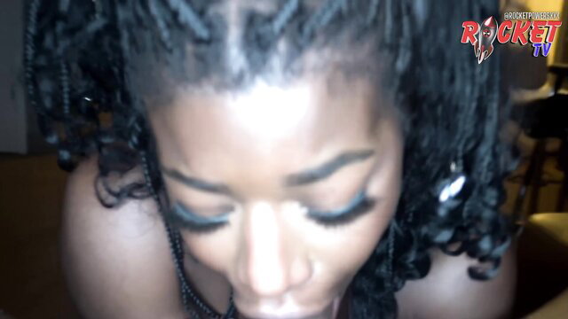 Closeup of sexy ebony brat with braids gazing seductively