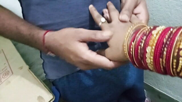 Couplefiree Indian hands with wedding ring and red bangles in intimate touch