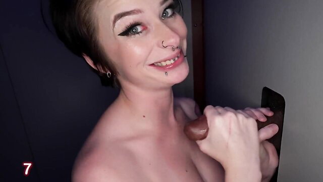 Kitty Lynn smiling with huge dildo at gloryhole, nude tits out