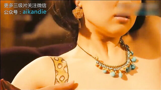 Asian beauty with leopard tattoo, turquoise necklace, gold earrings closeup