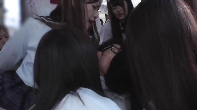 Group of sexy Japanese schoolgirls in uniforms crowding around man